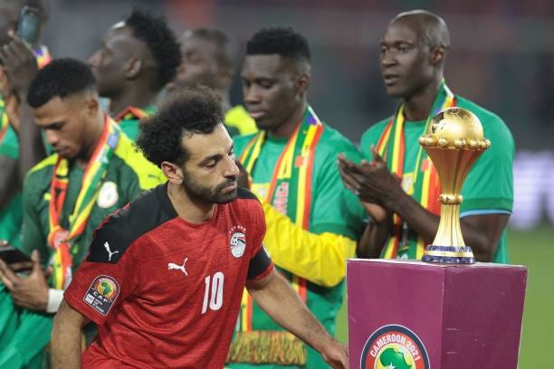 Egypt's forward Mohamed Salah walks past the trophy after loosing the Africa Cup of Nations 2021 final football match between Senegal and Egypt at...