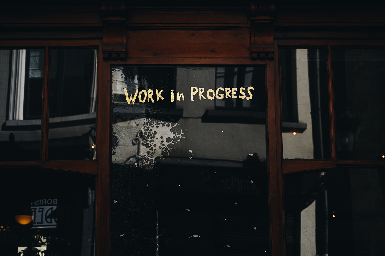 A sign on a window that says "work in progress"