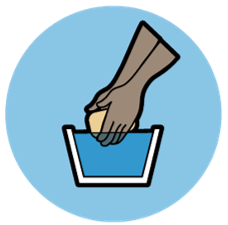 The circle icon for Water, Sanitation & Hygiene - an illustration of a pair of hands holding a bar of soap over a bucket of water.