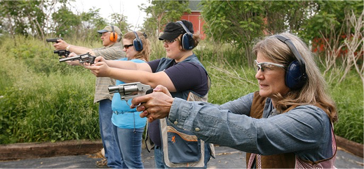 People holding guns at a shooting range