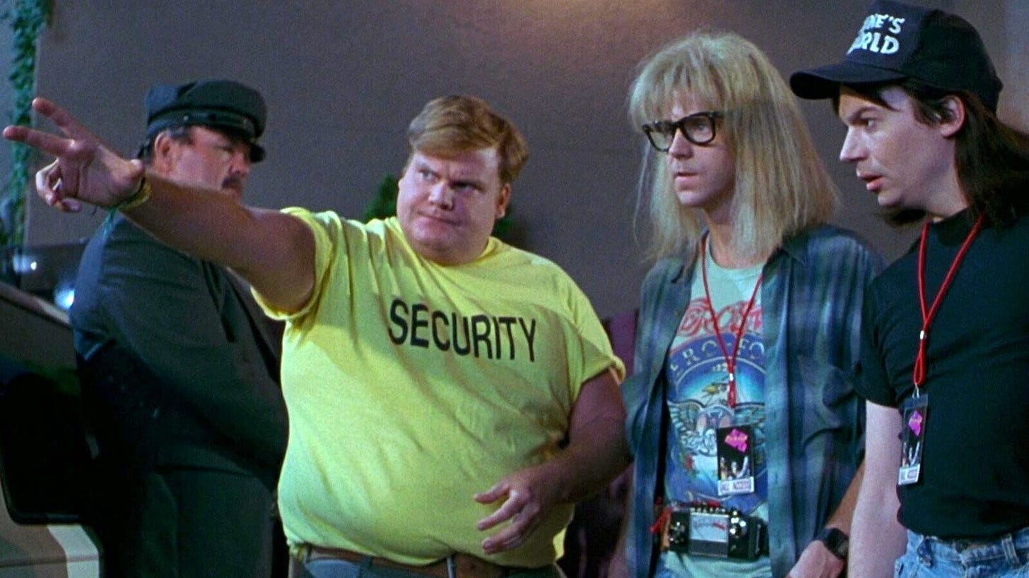 Still from Wayne's World showing Chris Farley as a security guard pointing to show the record exec's limo to Garth and Wayne