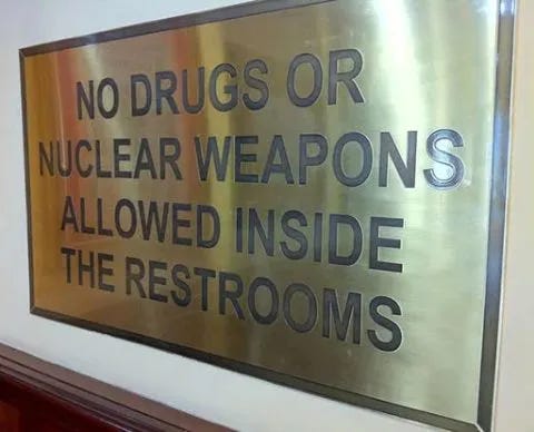 Cedule: Drogy a jaderné zbraně nejsou na toaletách povoleny