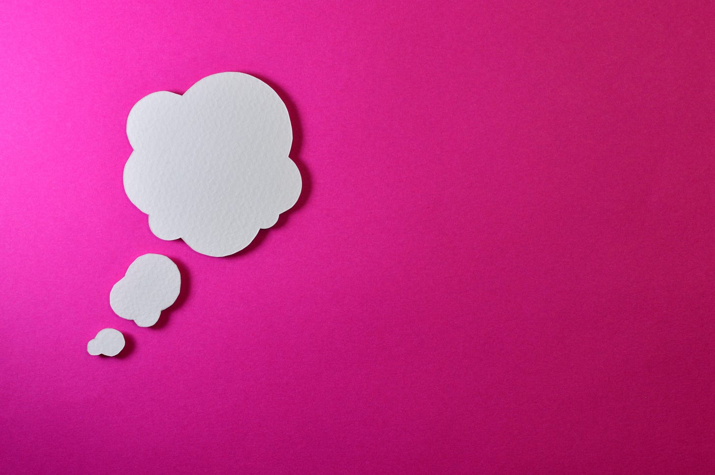 white thought bubble on pink background