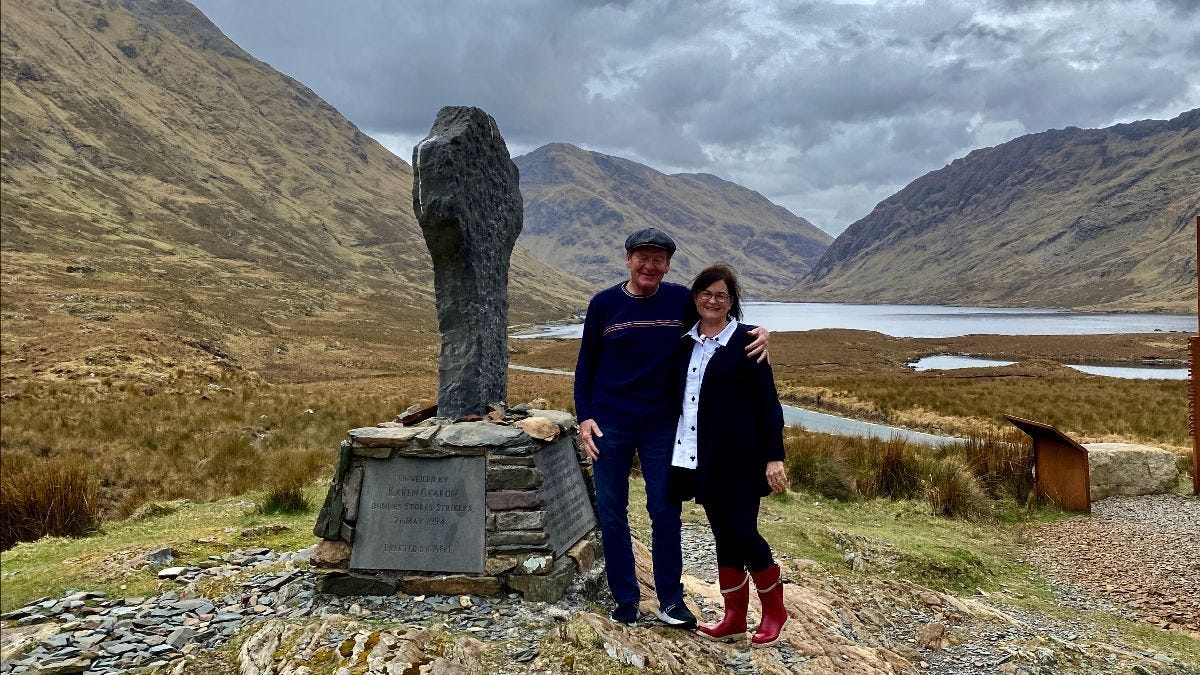 Man and woman standing next to famine memorial in the Doolough Valley, County Mayo, Ireland