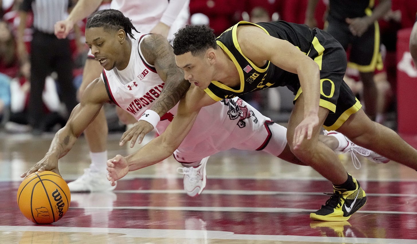 Wisconsin guard Kamari McGee (4) and Oregon guard Jackson Shelstad (3) dive for the ball