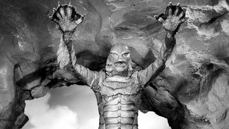 The Creature from the Black Lagoon with his arms up in the air.