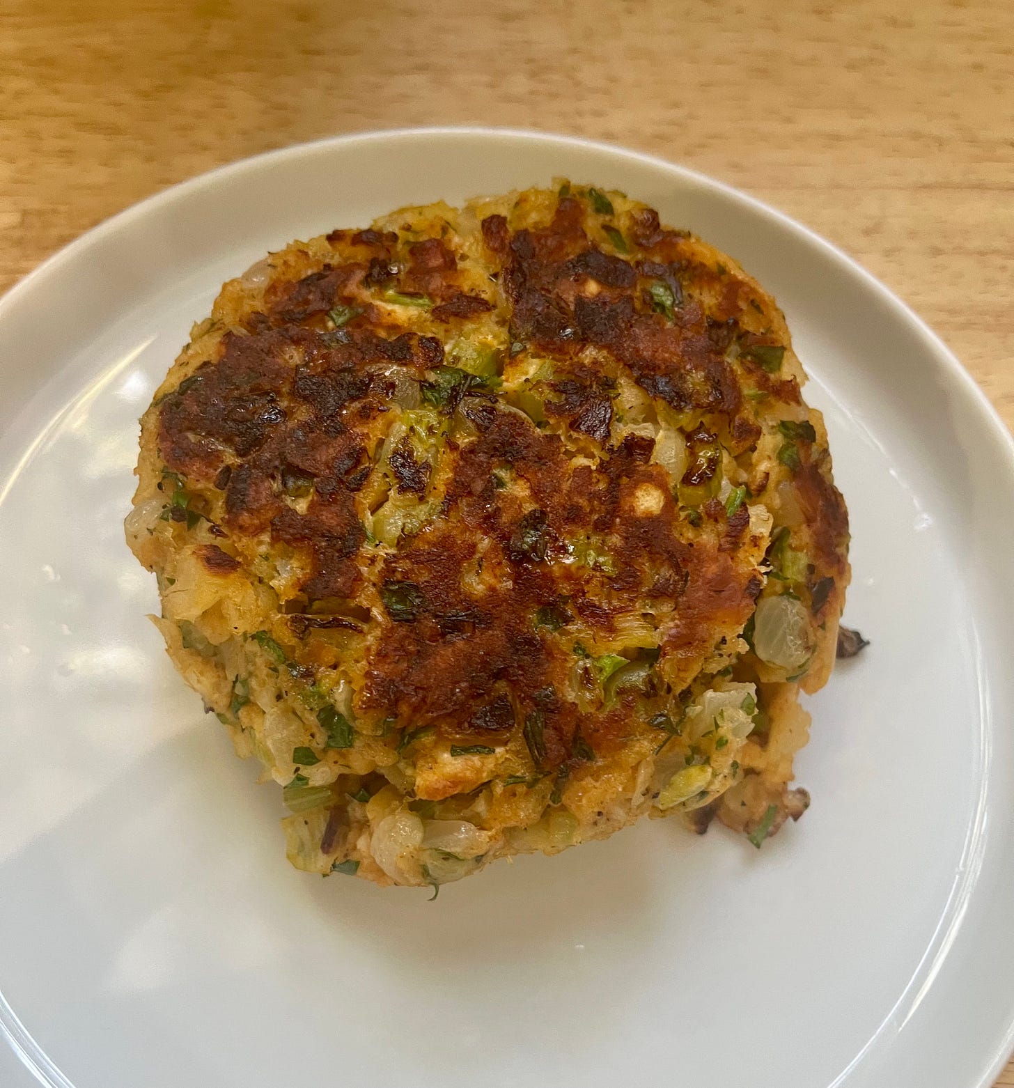 A perfectly browned cod cake with big chunks of fish and sauteed onion