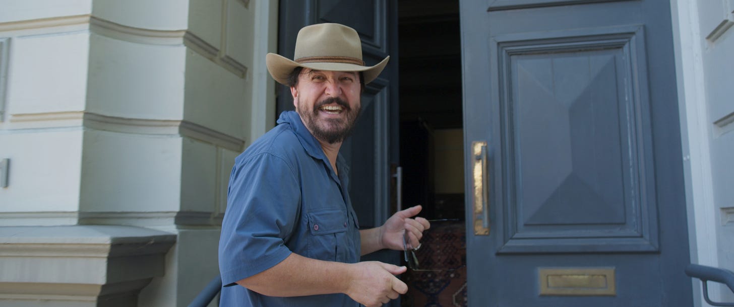 Man in cowboy hat grinning maniacally
