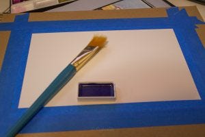 Painting in the wet requires more preparation. I've taped heavy paper to a board, and wet it with the flat brush. 