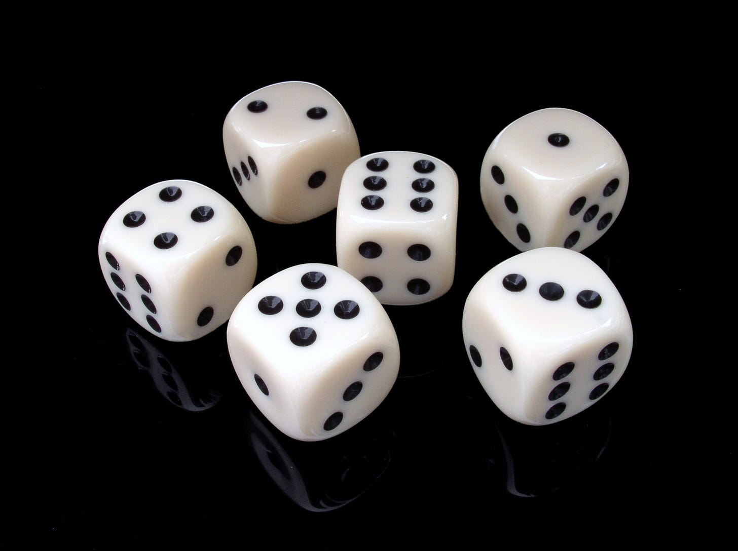 Six white dice on a black flat surface