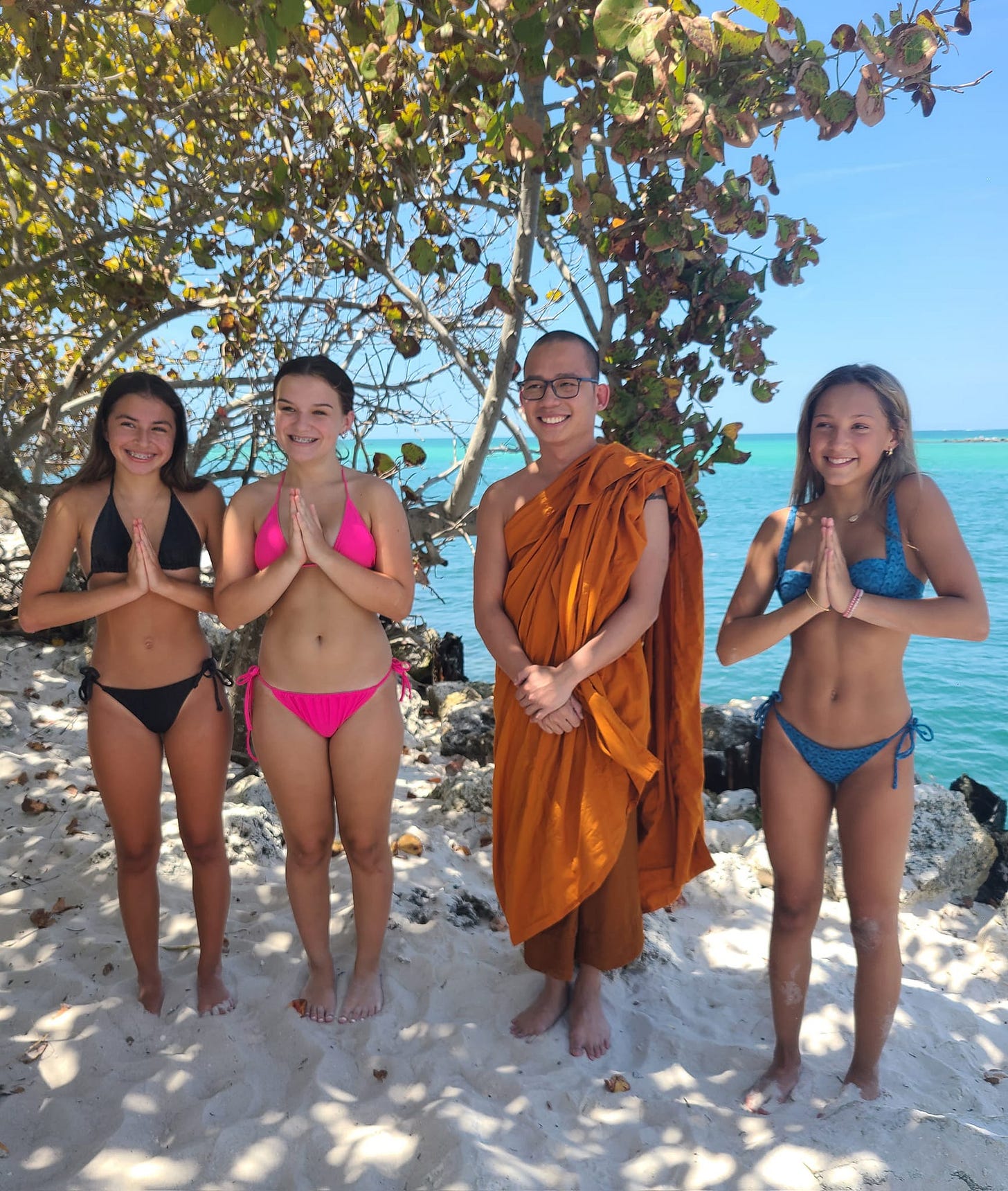 May be an image of 4 people, people practicing yoga, towel and beach