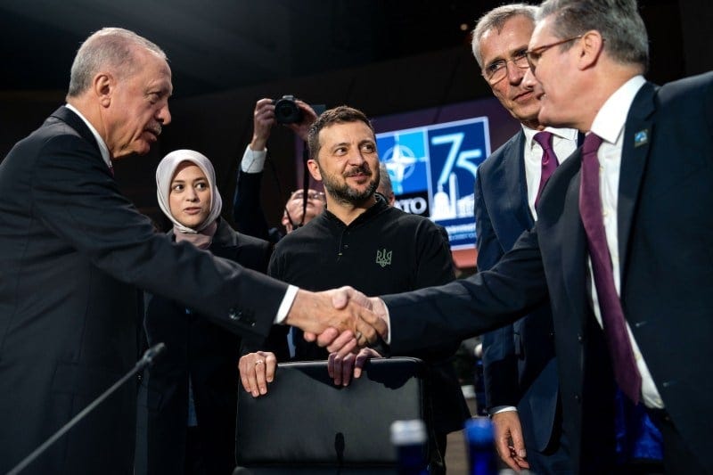 O presidente turco Recep Tayyip Erdogan aperta a mão do primeiro-ministro britânico Keir Starmer, enquanto o presidente ucraniano Volodymyr Zelensky observa antes do início de uma reunião do Conselho OTAN-Ucrânia.