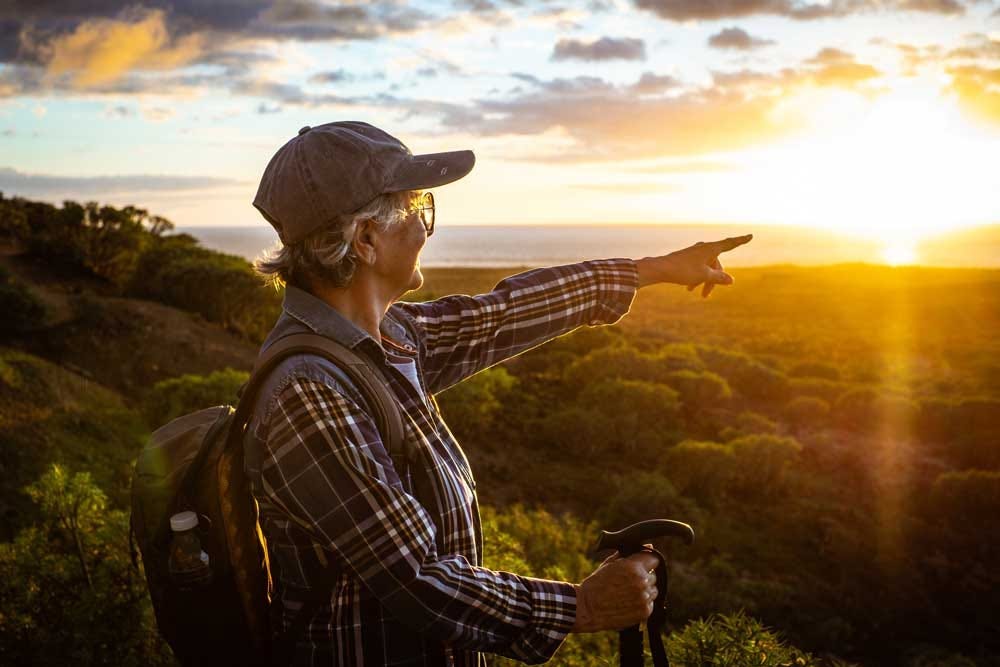 Elder woman enjoying an invirogating hike outdoors.