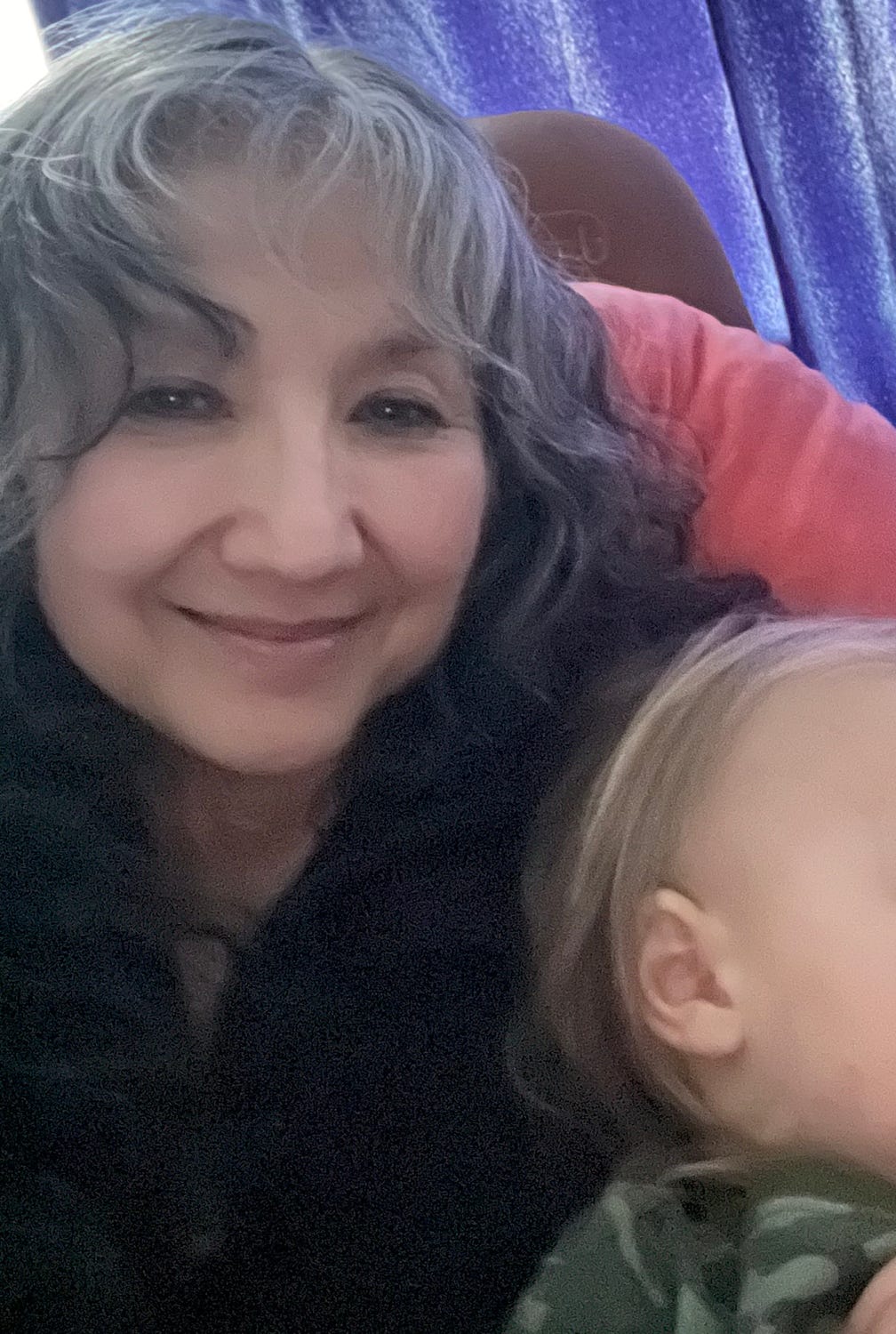 photo of Demian smiling at camera with sleeping grandson with face only partially shown photo of Demian smiling at camera with sleeping grandson with face only partially shown