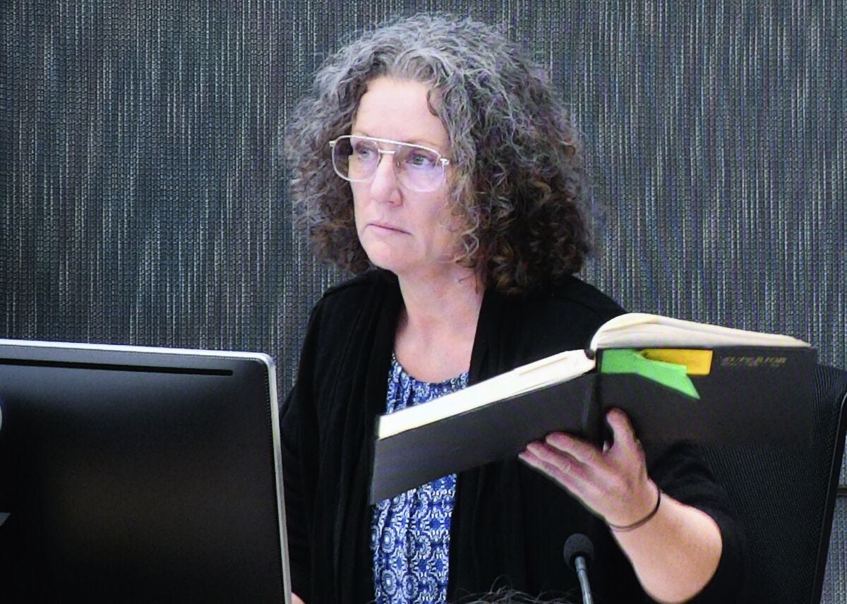 Kathleen Folbigg holds one of her diaries while appearing via video link screened at the New South Whales Coroners Court in Sydney, April 29, 2019. The Australian prosecutors office that proved 20 years ago mother Folbigg deliberately killed her four child now accepts there is reasonable doubt about her guilt, an inquiry has been told on Wednesday, April 26, 2023. (Peter Rae/AAP Image via AP)