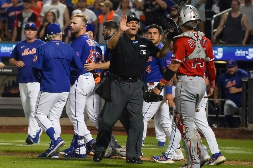 An umpire tries to restore order after Pete Alonso was hit in the back of the neck by a pitch and the benches cleared.