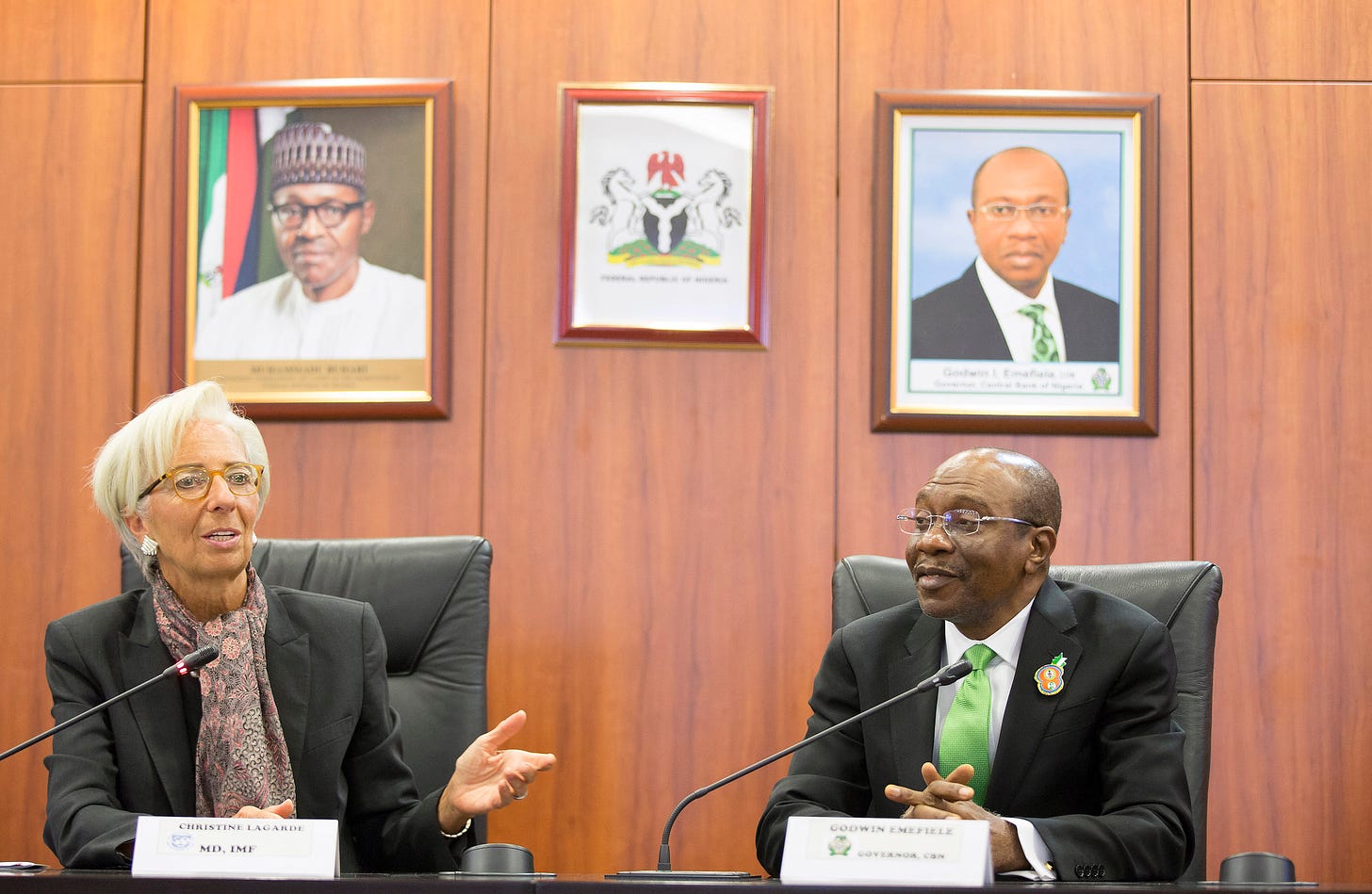 A French woman and a Nigerian man sitting behind microphones