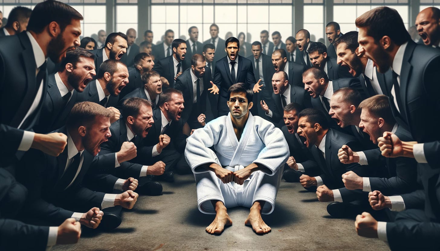An image depicting a man dressed in a white Brazilian jiu-jitsu gi with a matching white belt, sitting down looking upset. He is surrounded by a crowd of individuals in suits who are yelling at him, in a 16:9 aspect ratio. The man in the gi appears dejected and overwhelmed, with the aggressive crowd in suits spread out more widely, occupying the extended horizontal space. The indoor setting should emphasize the contrast between the solitary figure in the gi and the numerous suited individuals, conveying a tense and confrontational atmosphere.