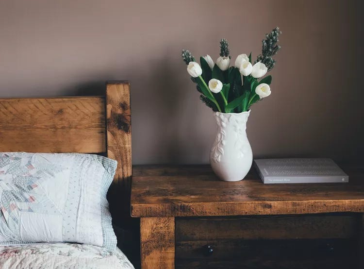 bedroom with wood furniture and fresh white tulips in a vase