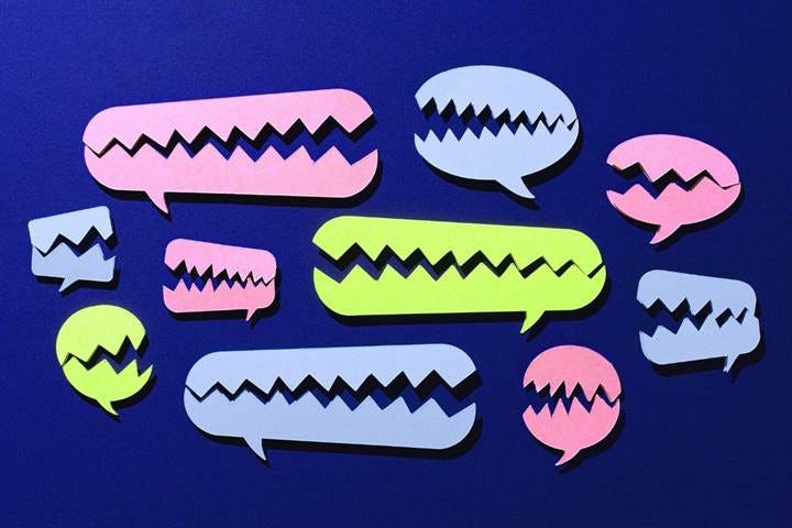 Green pink and light blue fractured speech bubbles that resemble talking mouths on a dark blue background