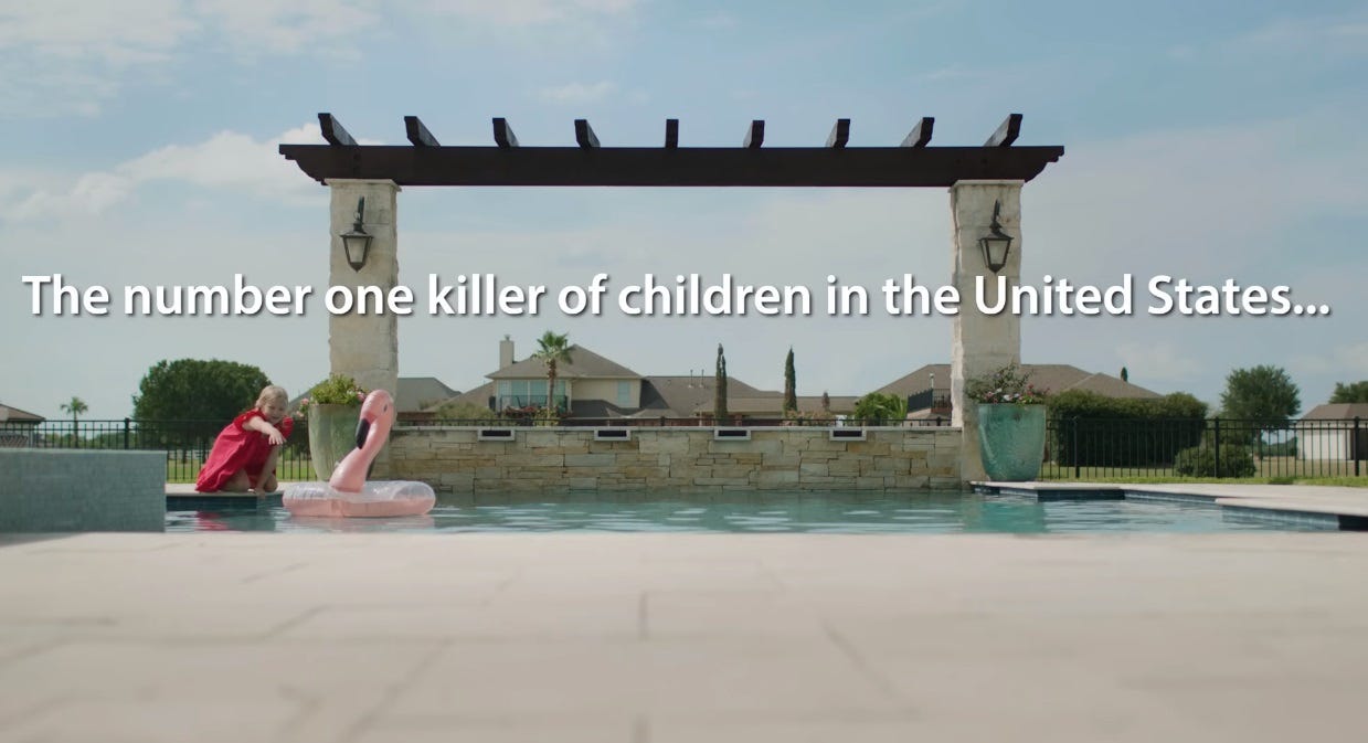 Wide shot of a young girl in a red dress at edge of a swimming pool, reaching for a pink flamingo floaty toy. Text: 'The number one killer of children in the USA...' (ellipses in original)