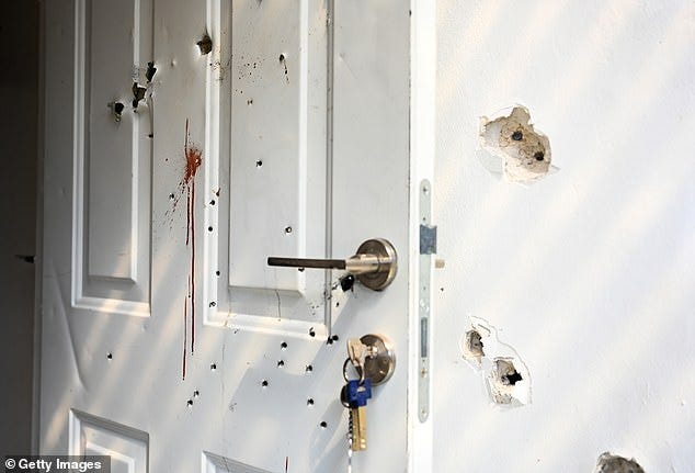 Gunshots and blood stains litter the walls and door of a house in the kibbutz near the border with Gaza