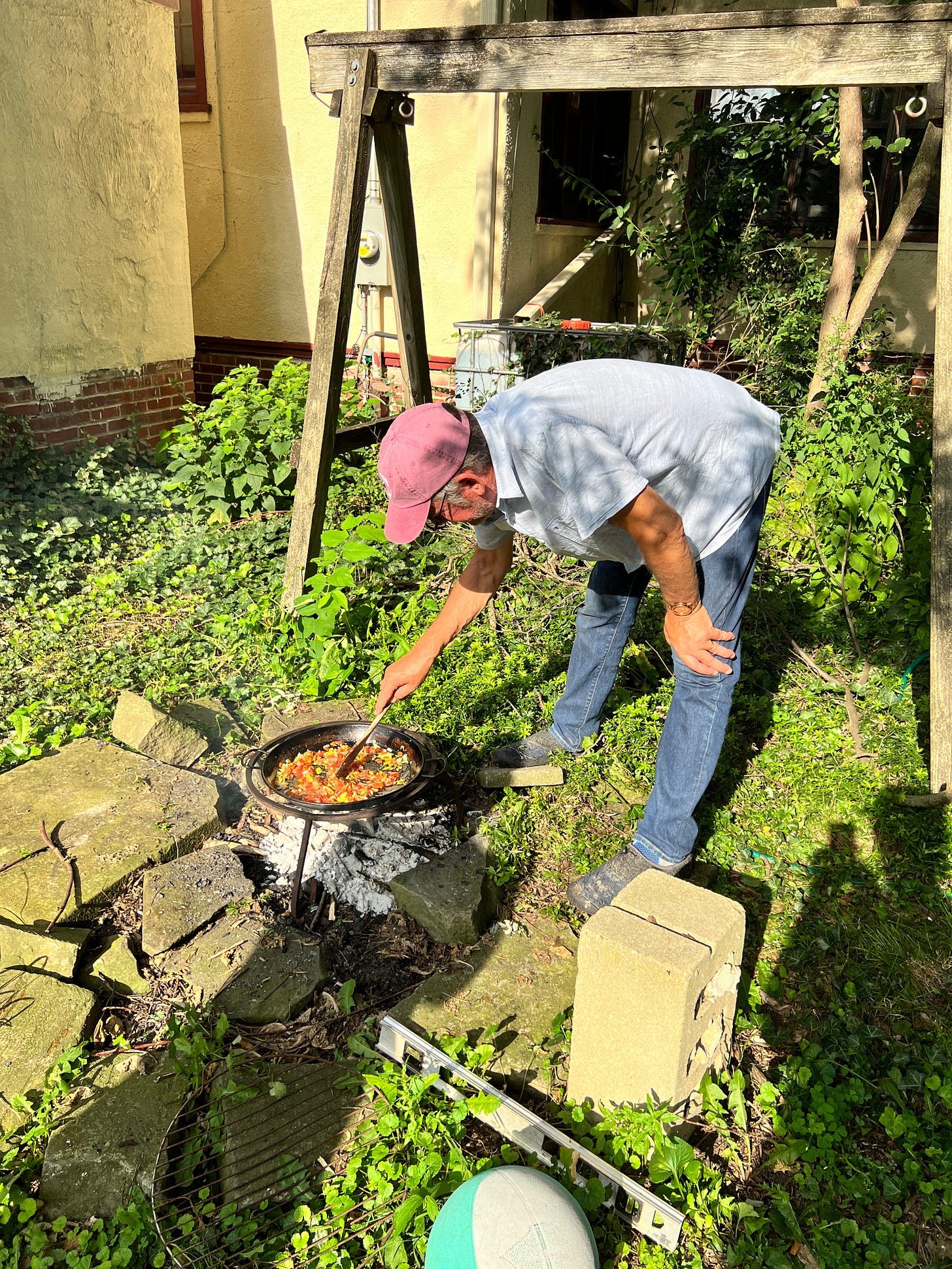 In this image, one of Bill's dinner party friends makes a colorful paella over a fire in his backyard. 