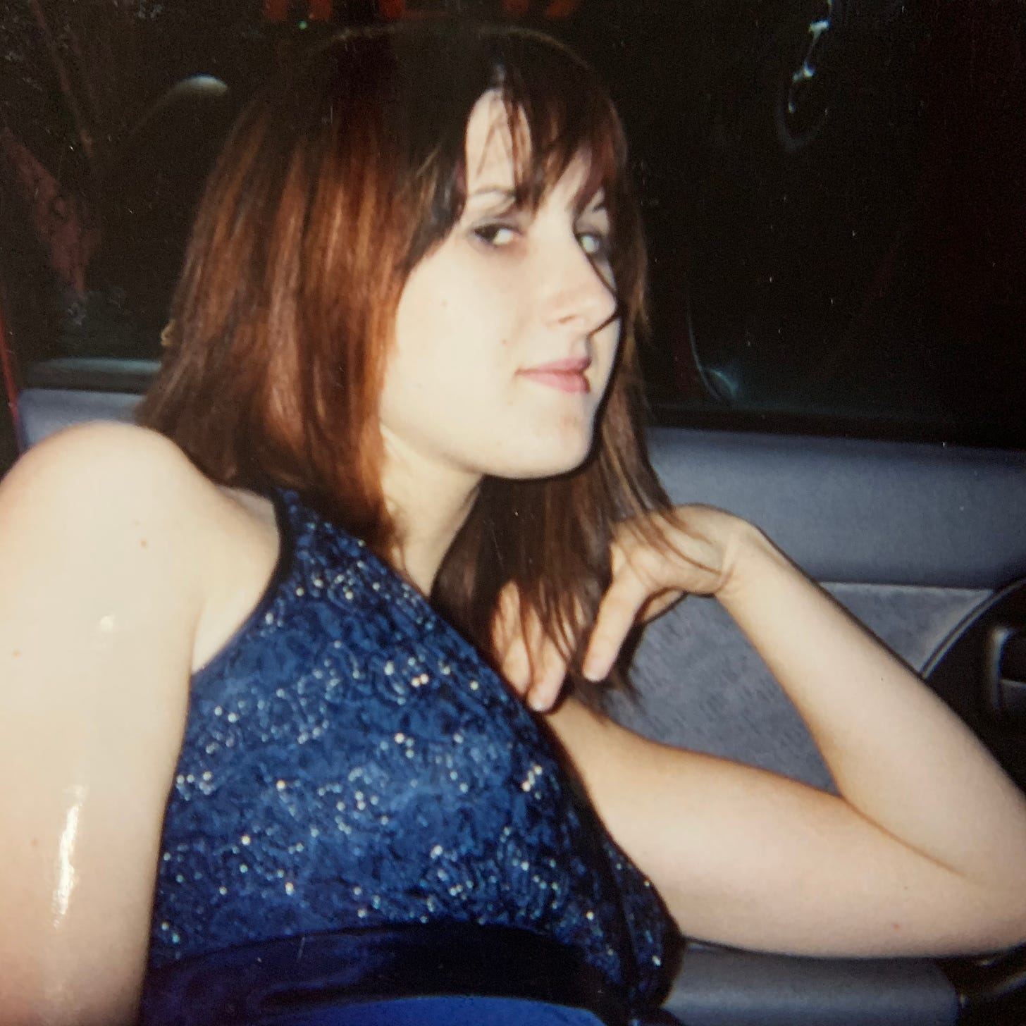 Lyric (then Kat), at age 18, in their car, in the parking lot of their work, on their day off.