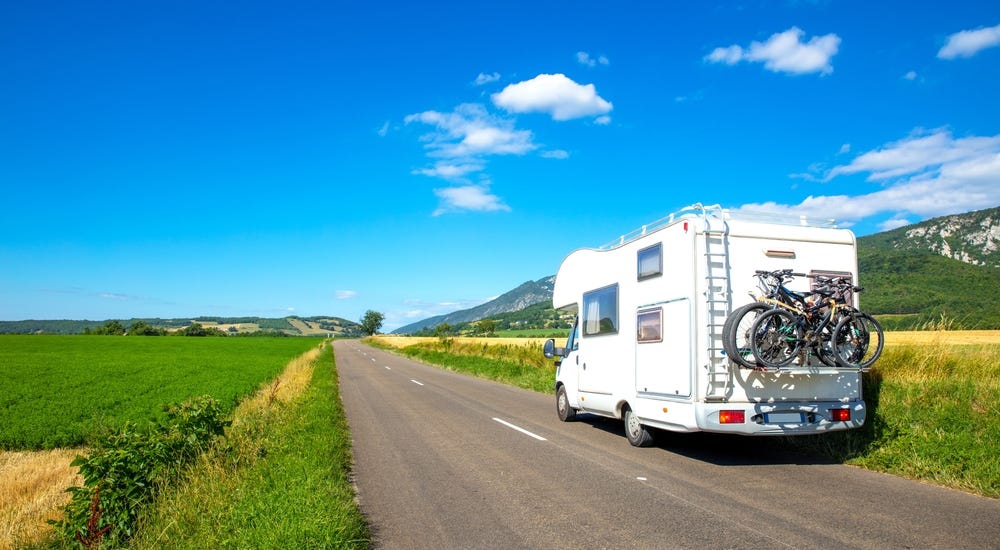 May be an image of campsite, bicycle, van and road