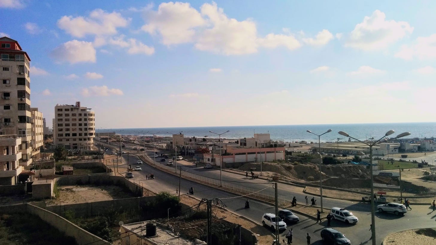 Gaza City in 2015. Buildings in the foreground along the coast, under a blue sky with a few big white clouds