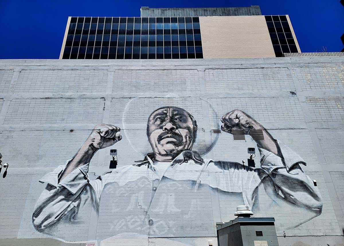 A mural in El Paso with a bracero showing his muscles.