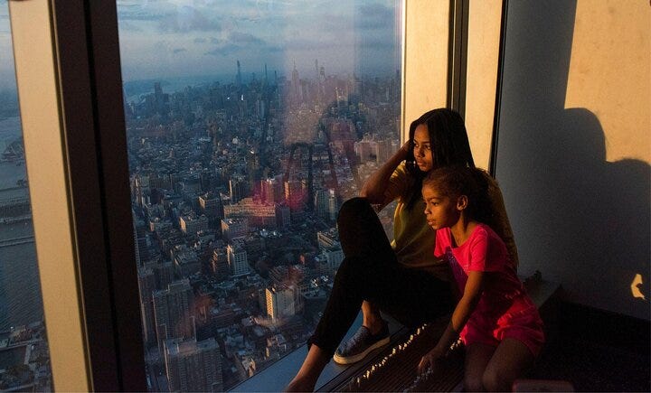 A family enjoys a view of NYC from the One World Trade Center.