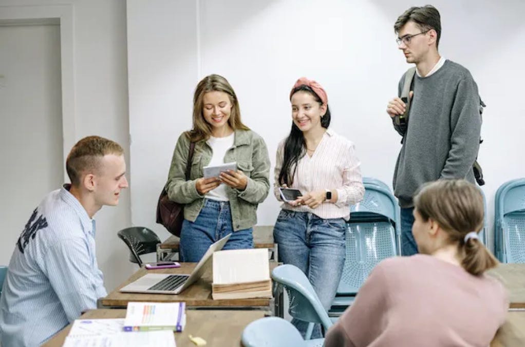 5 people gathered in an office space, talking