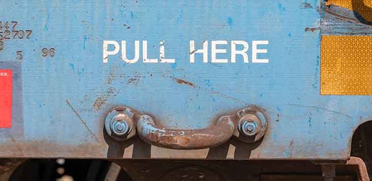Photo of a metal handle with an instruction label: "Pull here".