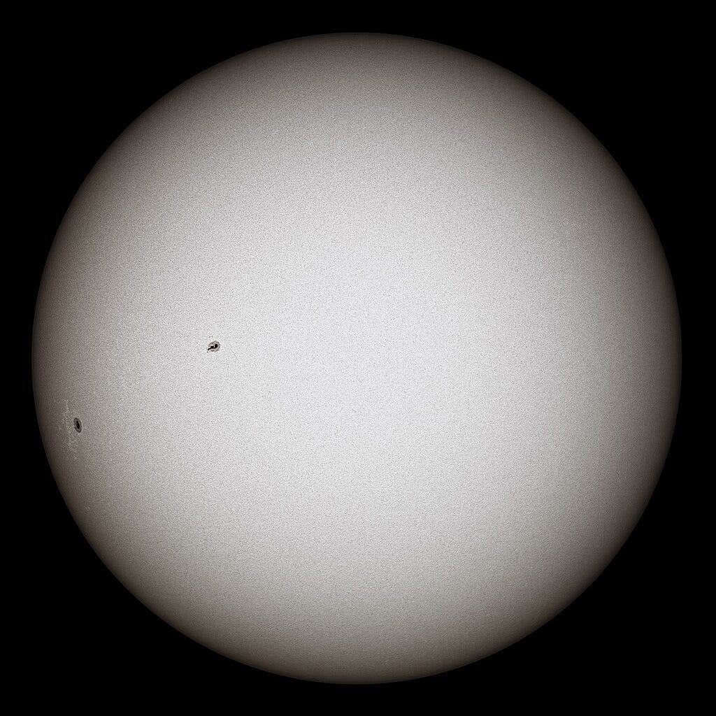 White glowing ball with black sunspots