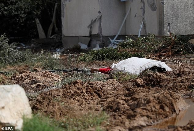 The body of a woman is covered with a blanket in Kfar Azza