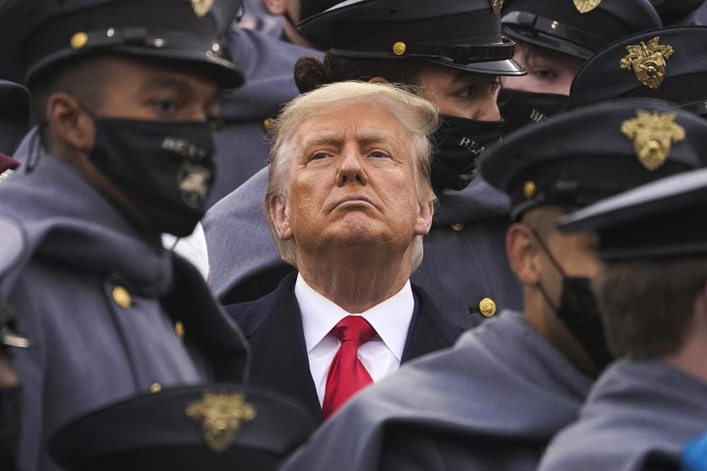 FIlE - Surrounded by Army cadets, President Donald Trump watches the first half of the 121st Army-Navy Football Game in Michie Stadium at the United States Military Academy, Saturday, Dec. 12, 2020, in West Point, N.Y. (AP Photo/Andrew Harnik, File)