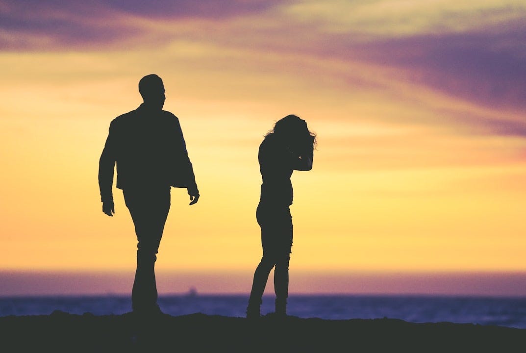 silhouette of man and woman under yellow sky