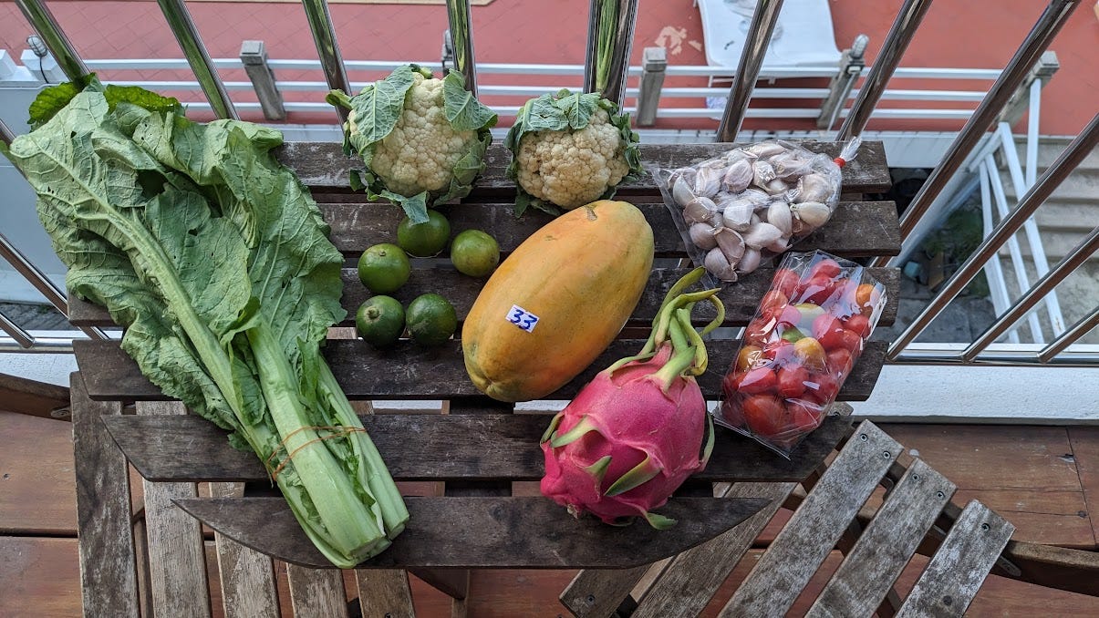 a table full of tropical produce and greens