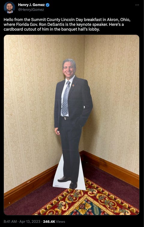tweet from Henry J. Gomez: Hello from the Summit County Lincoln Day breakfast in Akron, Ohio, where Florida Gov. Ron DeSantis is the keynote speaker. Here’s a cardboard cutout of him in the banquet hall’s lobby.