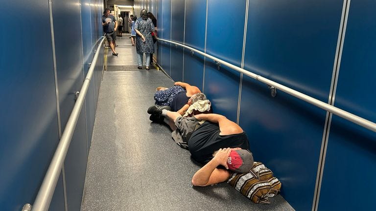 Travelers at Los Angeles International Airport sleep in a jetway for a delayed United Airlines flight to Dulles International Airport due to a widespread global outage early Friday, July 19, 2024, in Los Angeles. (AP Photo/Stefanie Dazio)