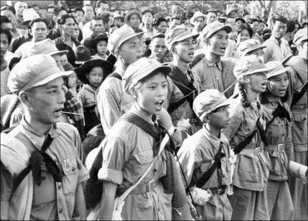 Communist soldiers from the East river unit, with among them several women, song an hymn to Mao Tse Tung glory as they arrive in Sham Chum, three...