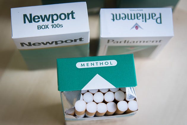 Packs of menthol cigarettes sits on a table.