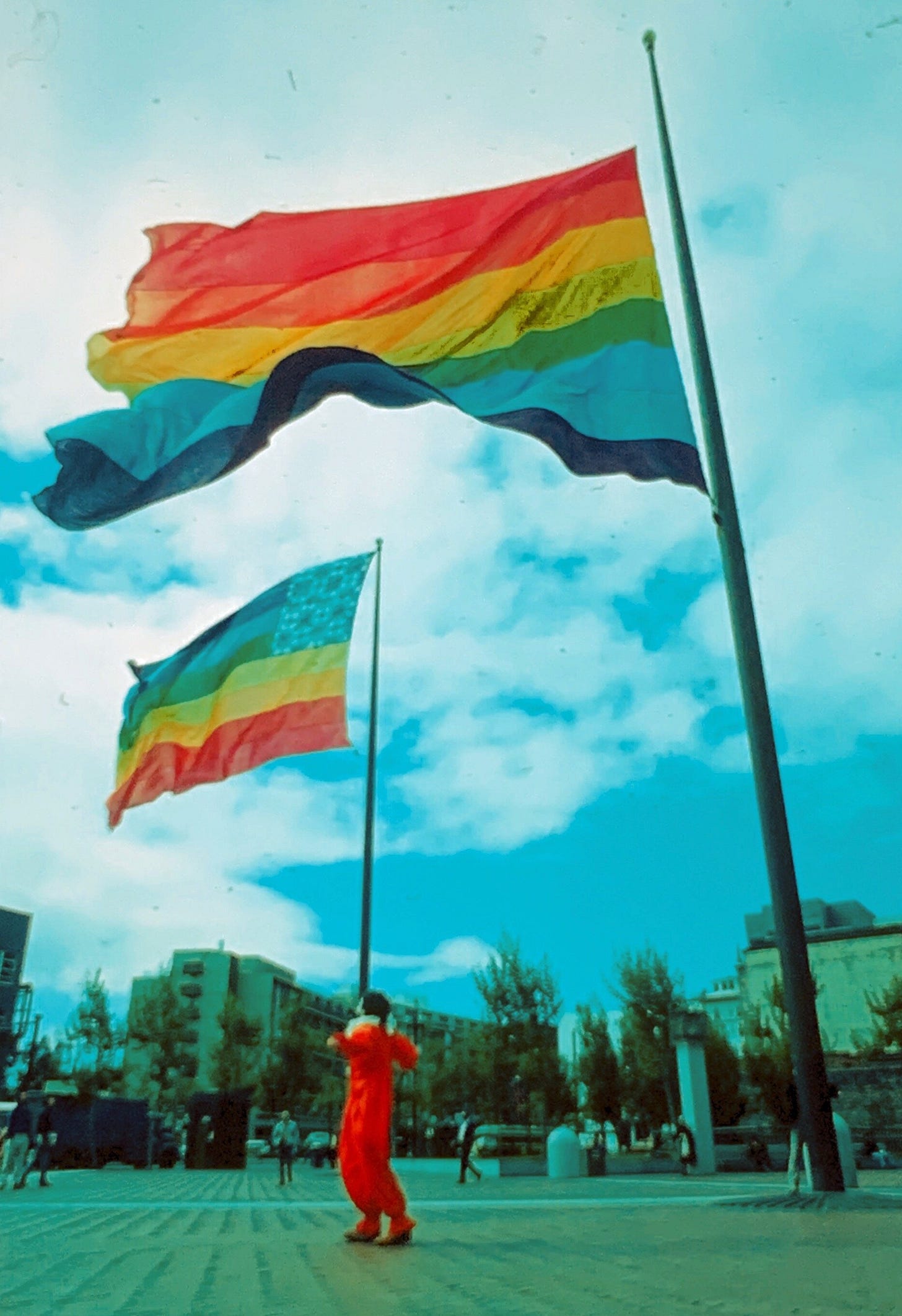 The two original eight-color rainbow flags flying at United Nations Plaza during San Francisco Gay Freedom Day 1978. A segment of the flag in the foreground, with the pink stripe at the top, was donated to the GLBT Historical Society in April 2021. Photograph by Mark Rennie, courtesy of the Gilbert Baker Foundation.