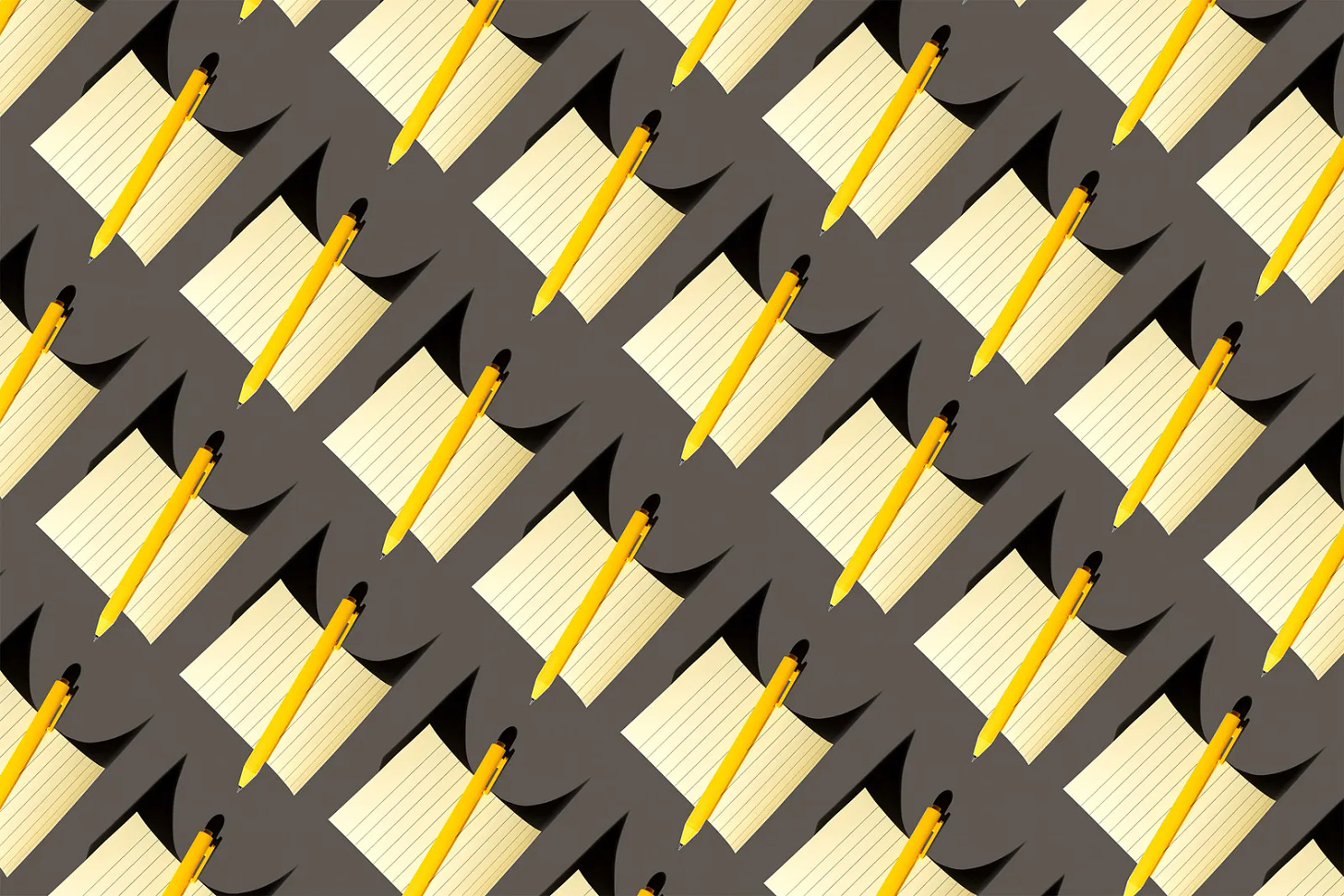 Um pattern de blocos de notas amarelos com canetas amarelas em cima deles em um fundo cinza