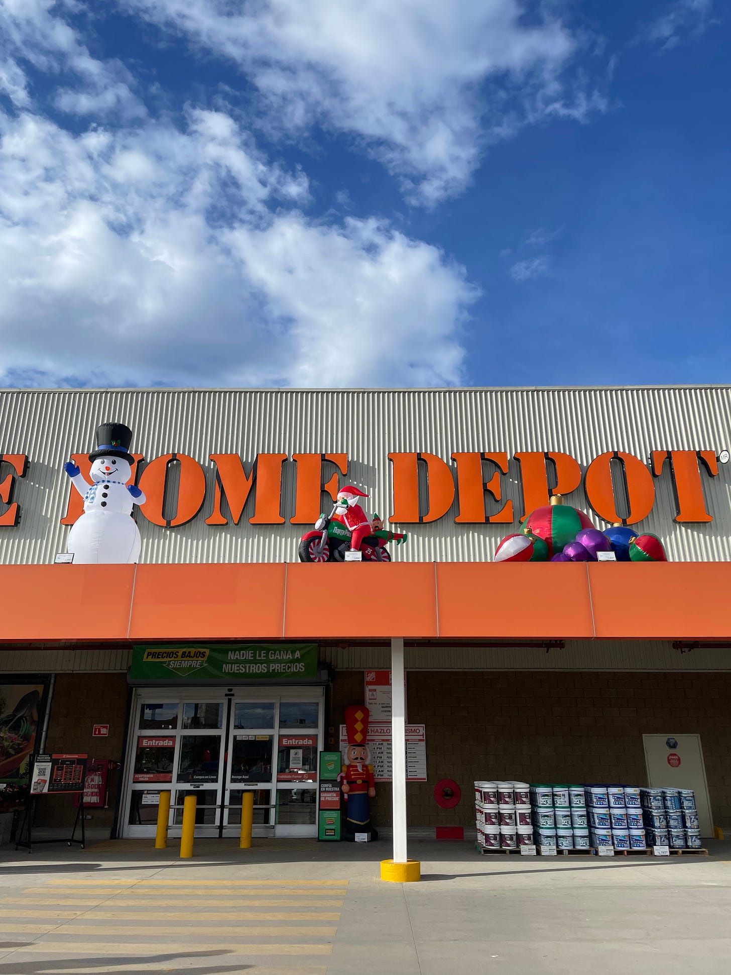 A photo of the entrance to Home Depot, showing inflatable Christmas decorations on top of the building.