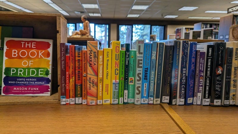 A selection of LGBTQIA2S+ Pride books at the library, arranged in a rainbow of book covers