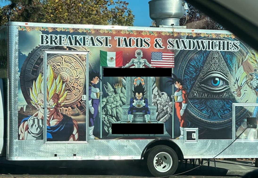 A taco truck that’s boastin’ BREAKFAST, TACOS & SANDWICHES with a bunch a’ stuff painted on it’s side. We’ll get into the details in today’s trivias, but at a high level it’s got some anime characters on it, plus a big Illuminati eye, plus a circular design that has a vaguely Aztec feel to it. Oh, an’ also a Mexican flag an’ a U.S.A. flag.