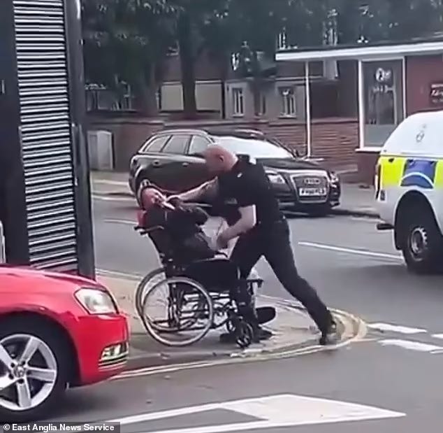 A man in a wheelchair getting punched in the face by a police officer