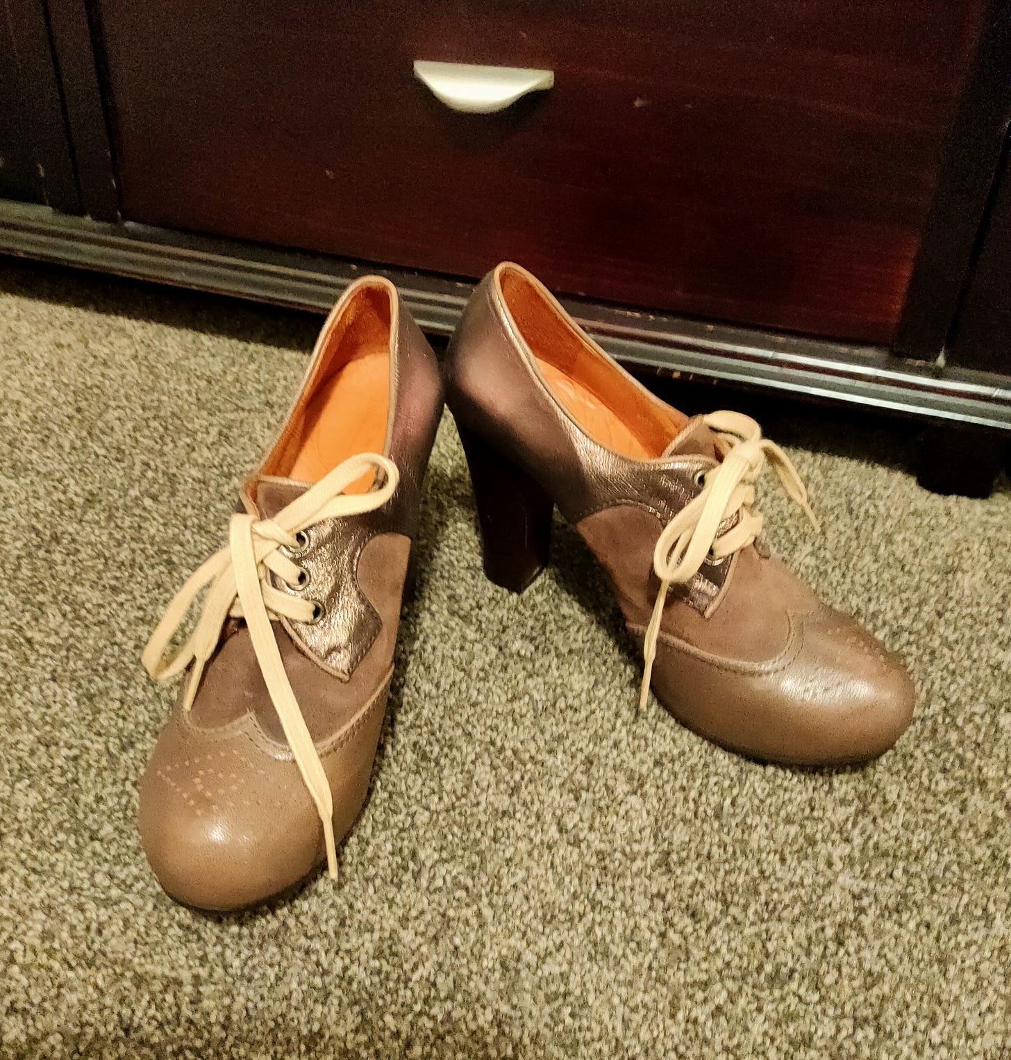 High-heeled brogues in brown and bronze leather, brown suede, and light tan shoelaces. They look like a pair of sensible shoes turned 40 and decided to do whatever the hell they want, but still be comfortable because honestly they're old enough to appreciate the joys of a nice cup of tea and a 10pm bedtime.